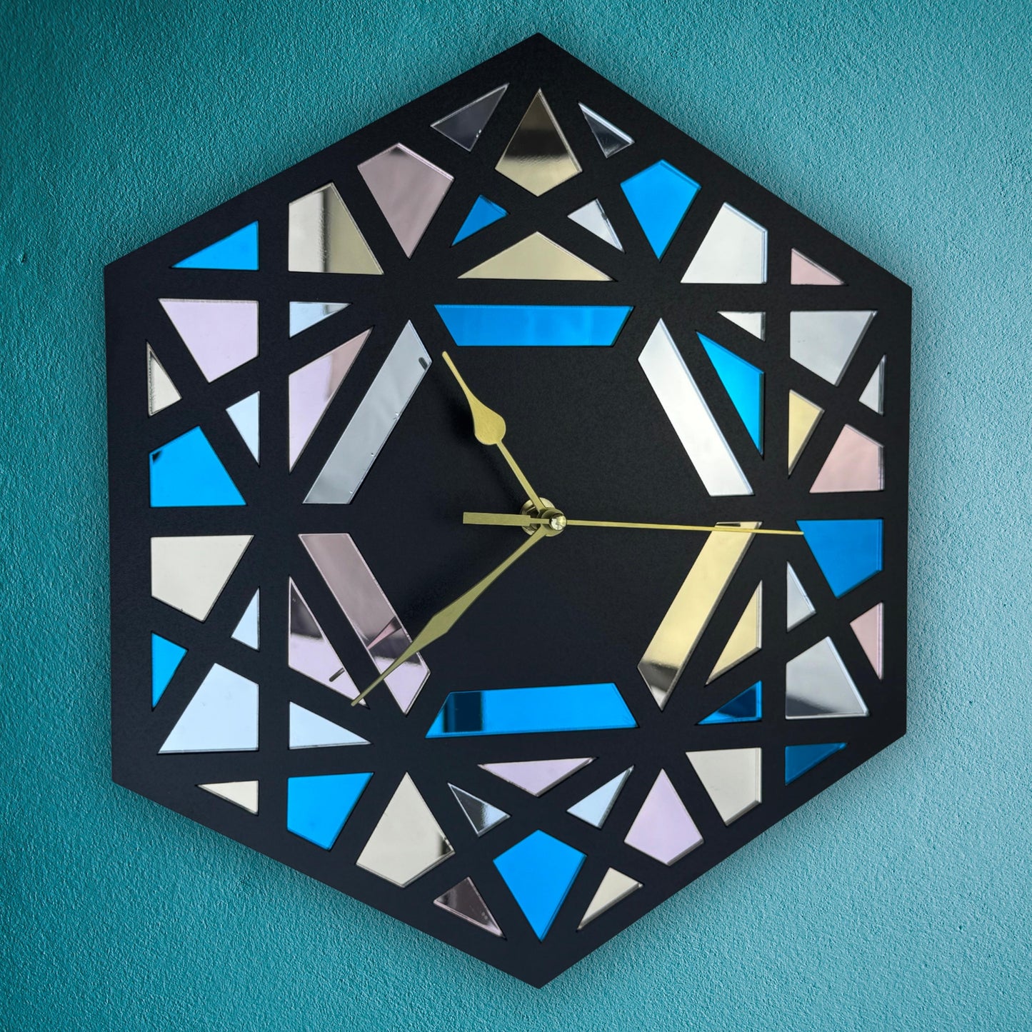 Geometric wall clock with a black frame on a teal background