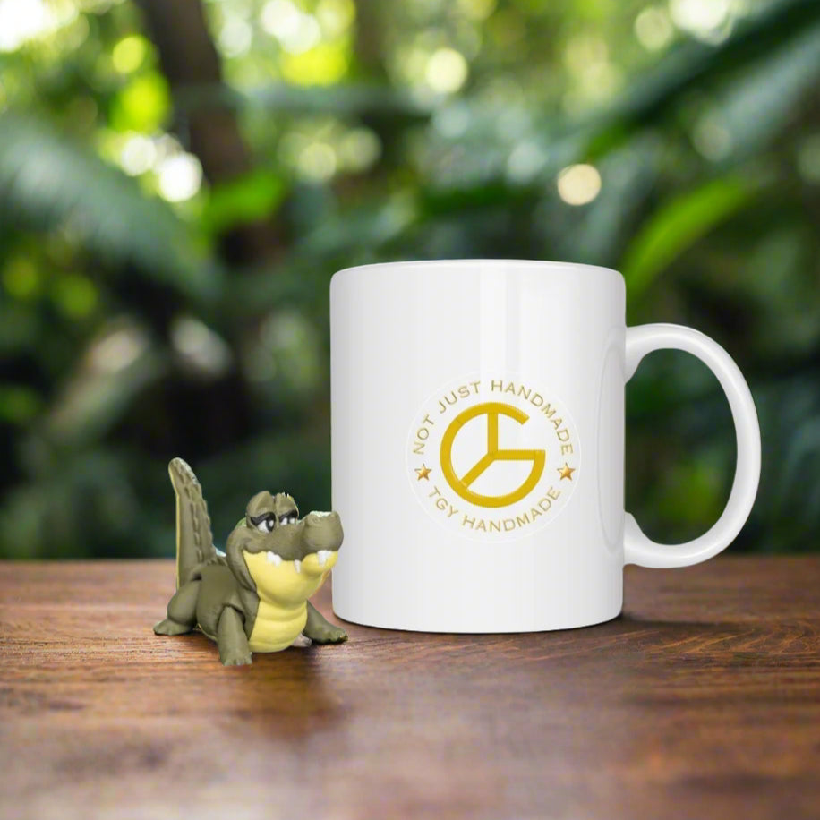 White mug with a logo and text on a wooden surface with toy alligator