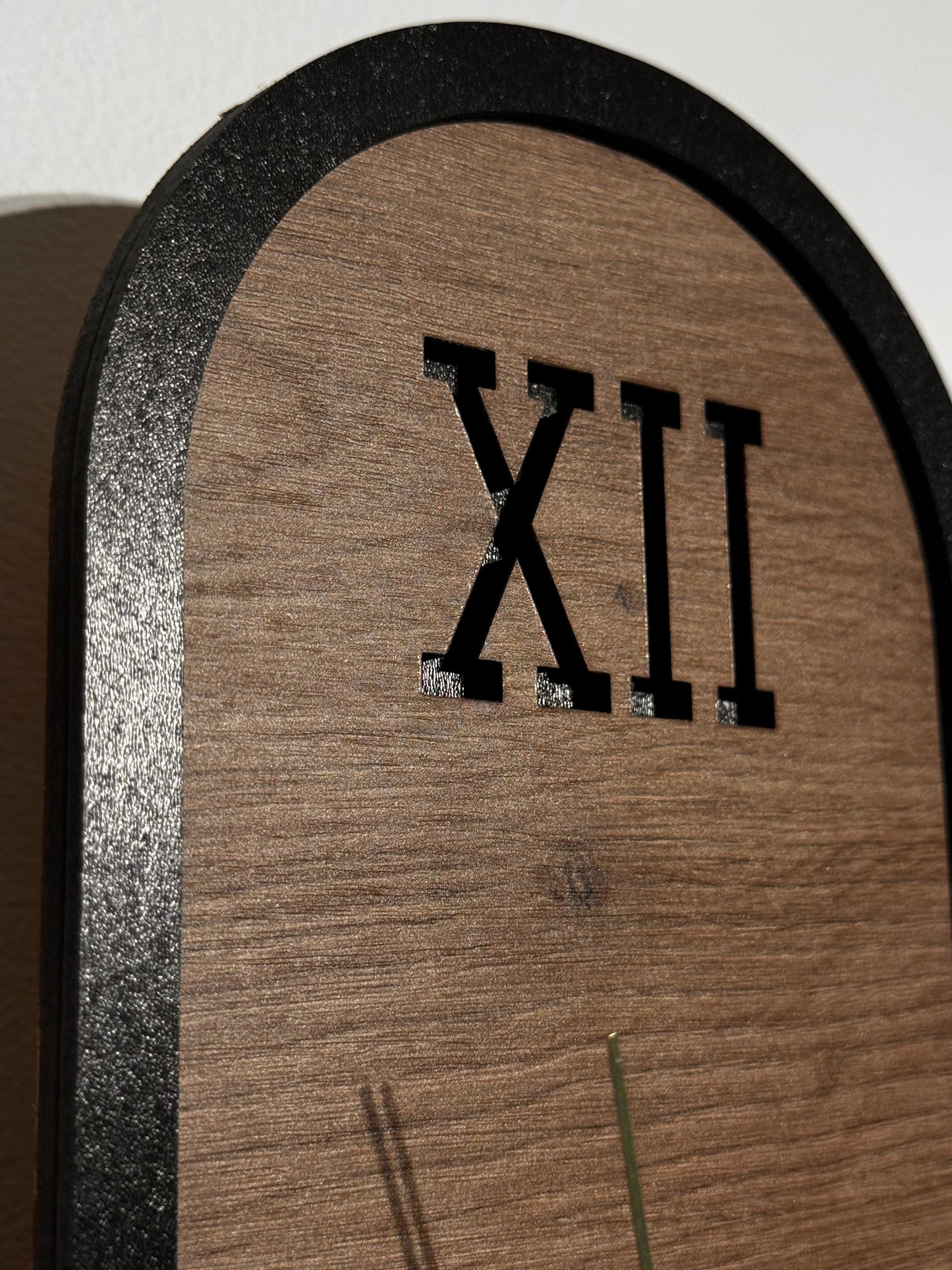 The clock mounted on a living room wall, blending seamlessly with modern decor and adding warmth with its cherry wood finish.