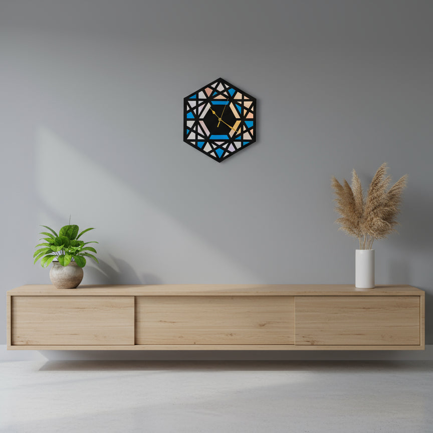 Geometric wall clock on a gray wall above a wooden console table with decorative plants.