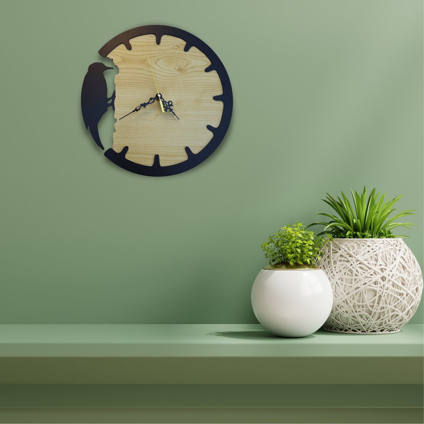 Wooden wall clock on a green wall with two potted plants on a shelf below.