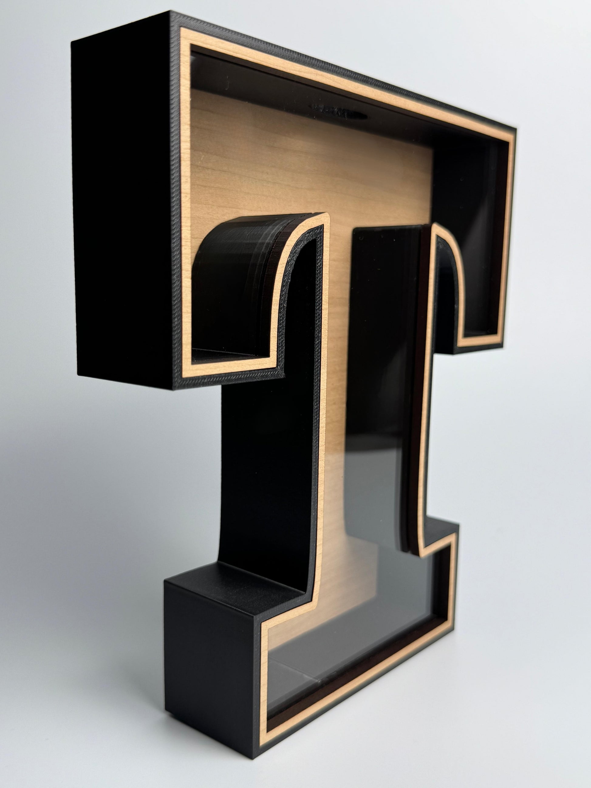 Black and gold letter 'T' on a white background