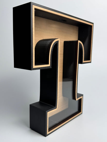 Black and gold letter 'T' on a white background