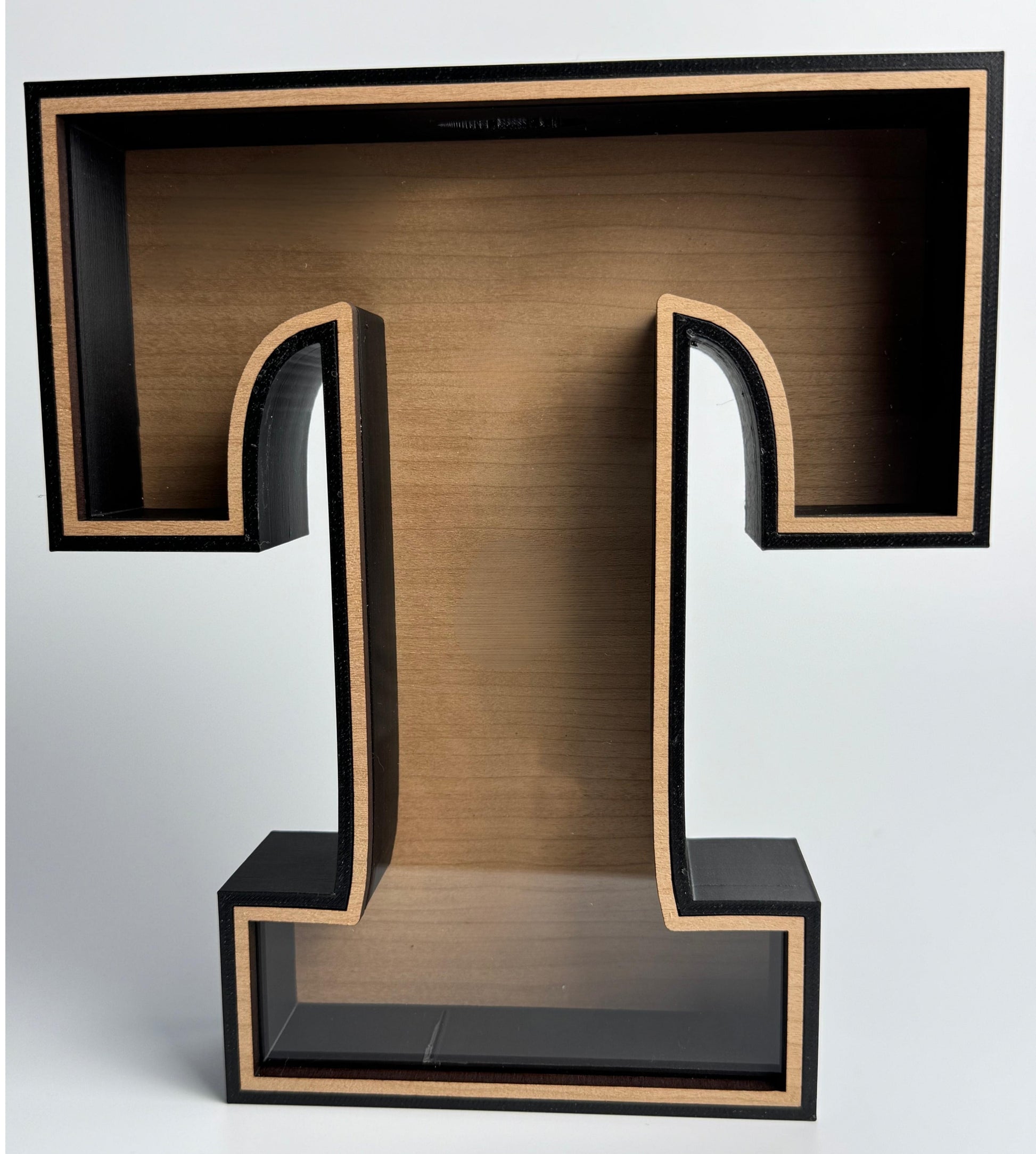Wooden letter 'T' with a black frame on a white background