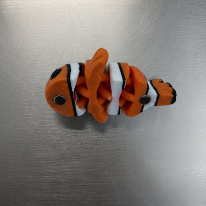 Fishing lure with orange, black, and white colors on a metallic surface