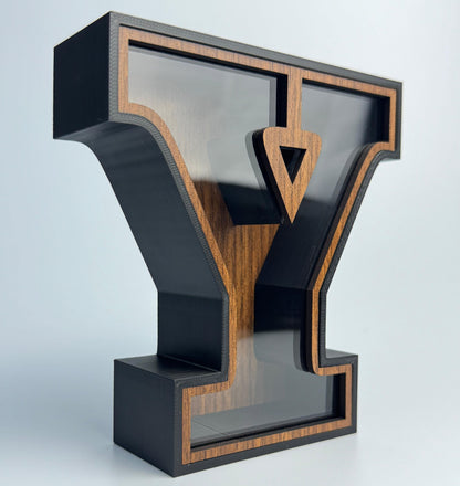 Decorative letter 'Y' with black and wood finish on a light gray background
