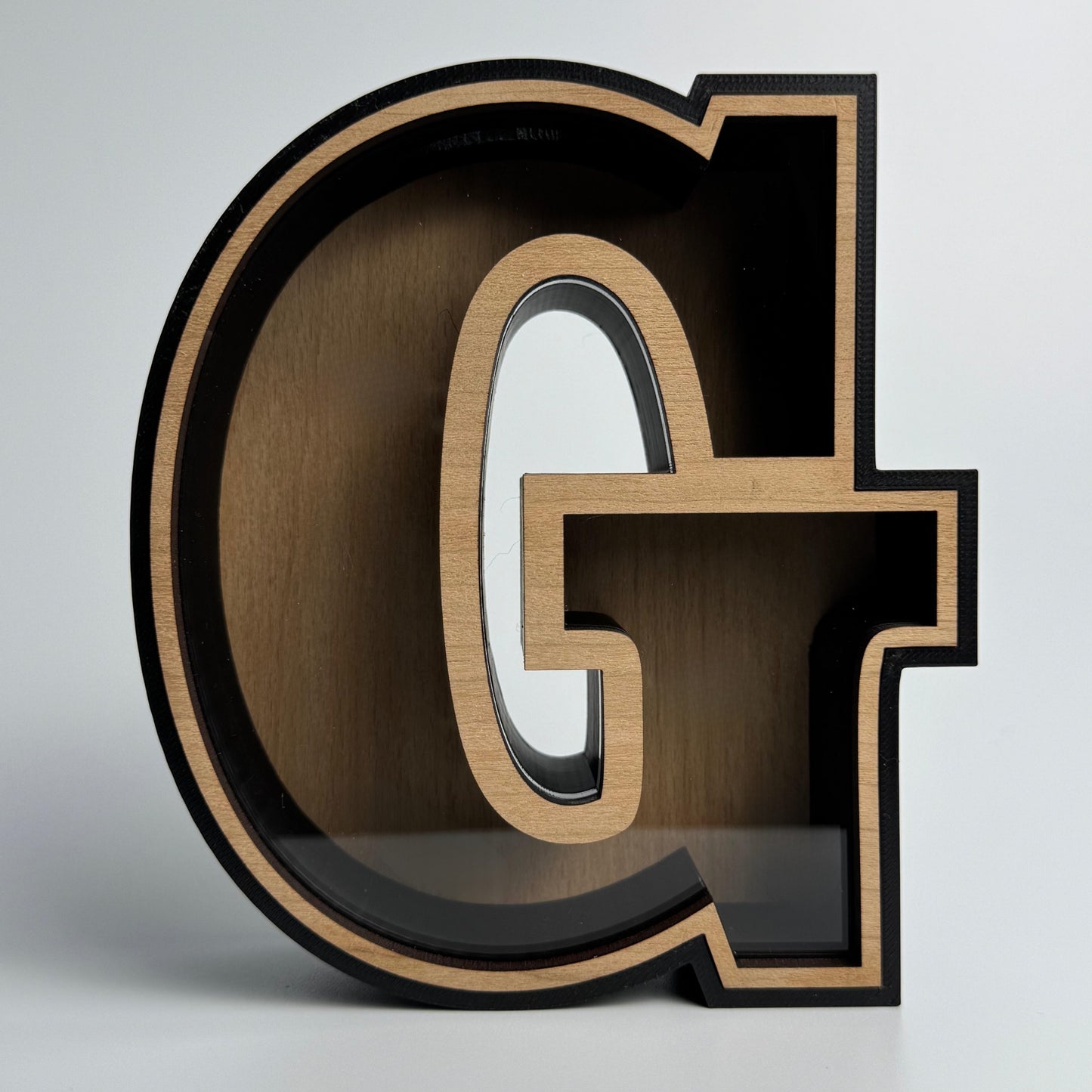 Wooden letter 'G' on a gray background