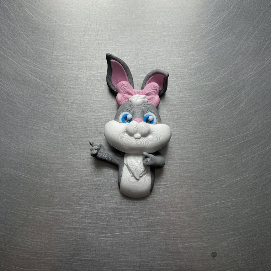 Fridge magnet shaped like a cartoon rabbit with a pink bow on a metallic surface