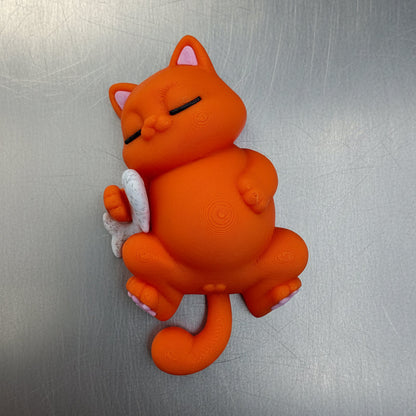 Orange cat-shaped magnet on a metallic surface