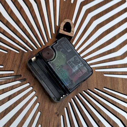 Small electronic device on a wooden surface with a sunburst pattern