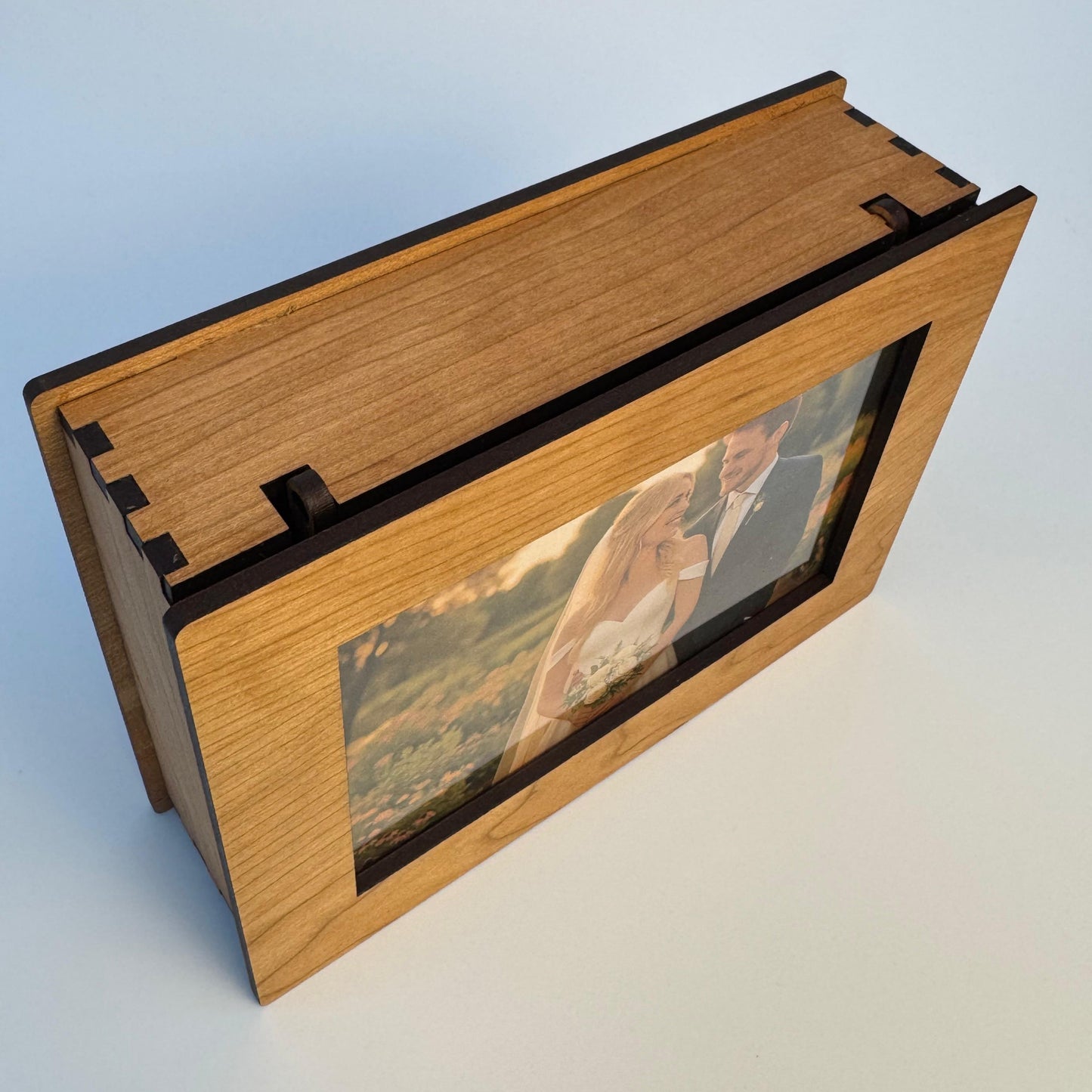 Wooden photo album with a couple on a mountain landscape on a light blue background