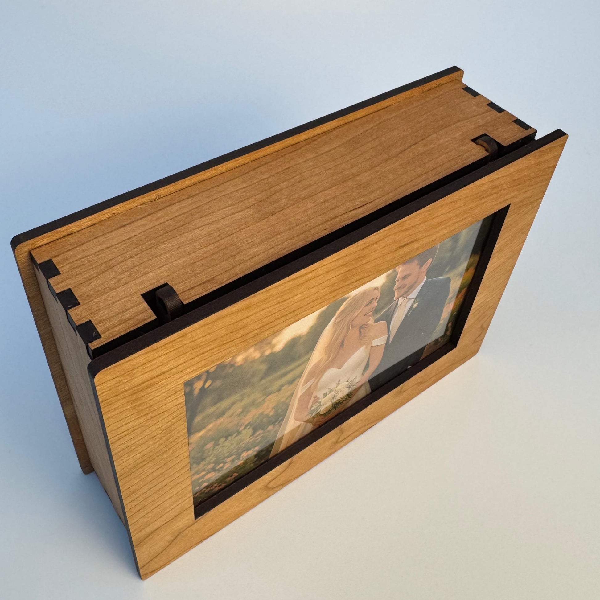 Wooden photo album with a clear cover on a light gray background