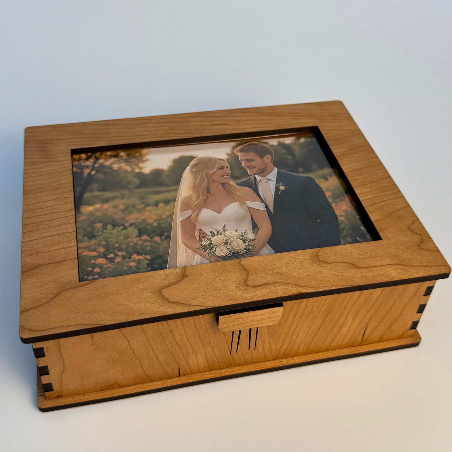Wooden box with a glass lid featuring a photo of a couple on a white background