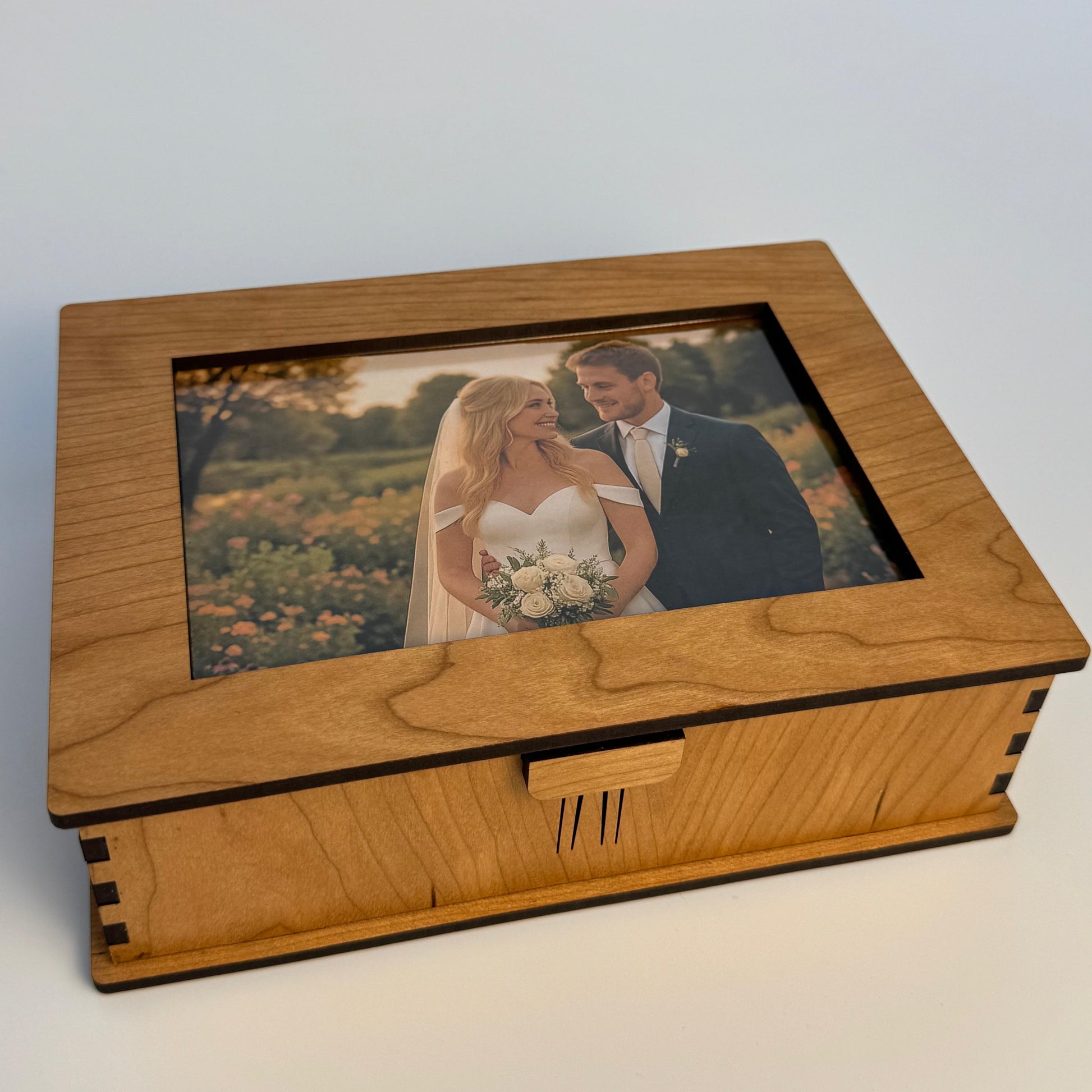 Wooden box with a glass lid featuring a wedding photo of a couple.