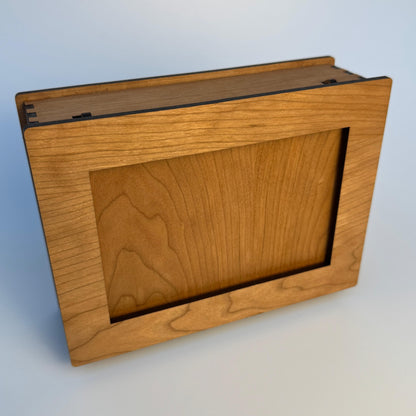 Wooden box with a hinged lid on a light gray background