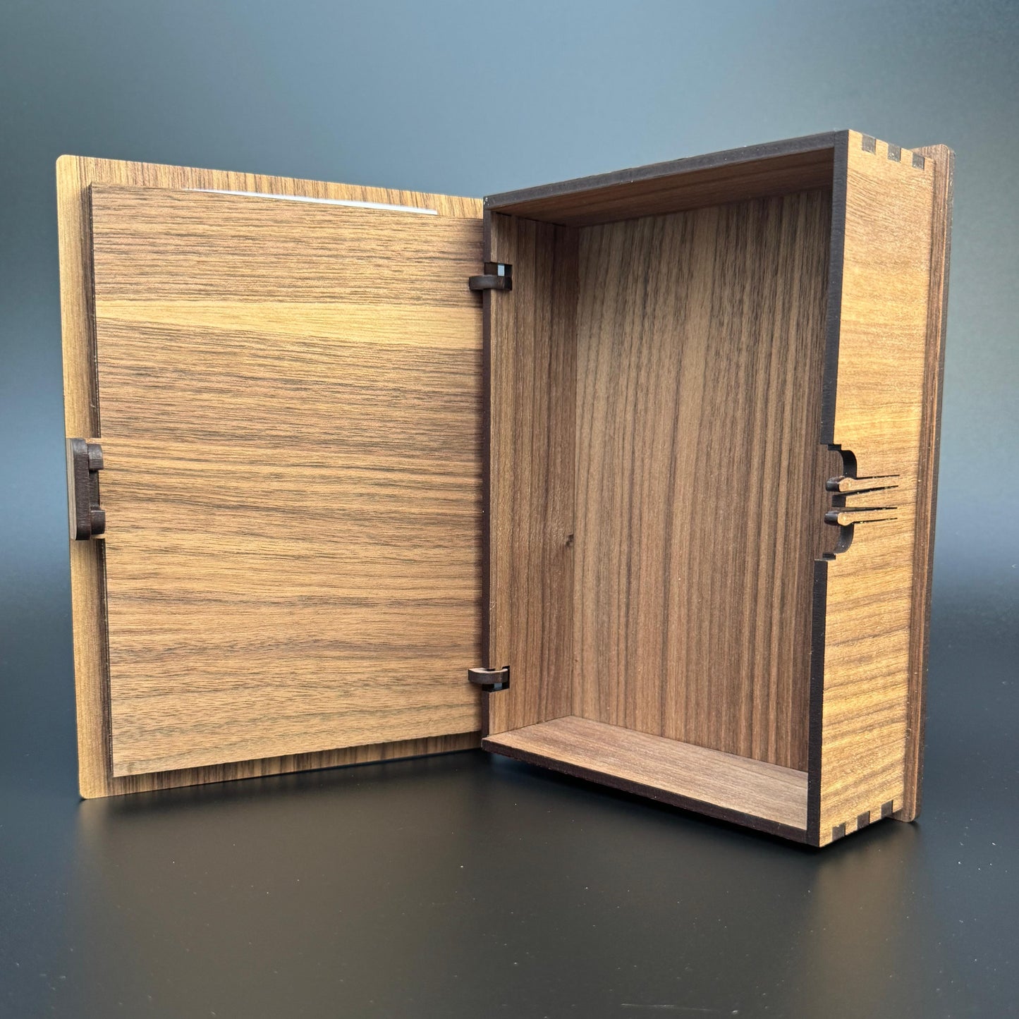 Wooden box with a lid open on a dark surface