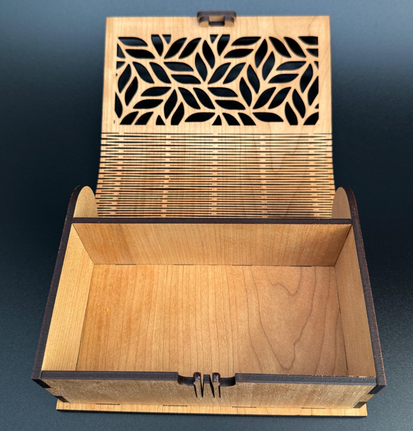 Wooden box with laser-cut lid on a dark blue background