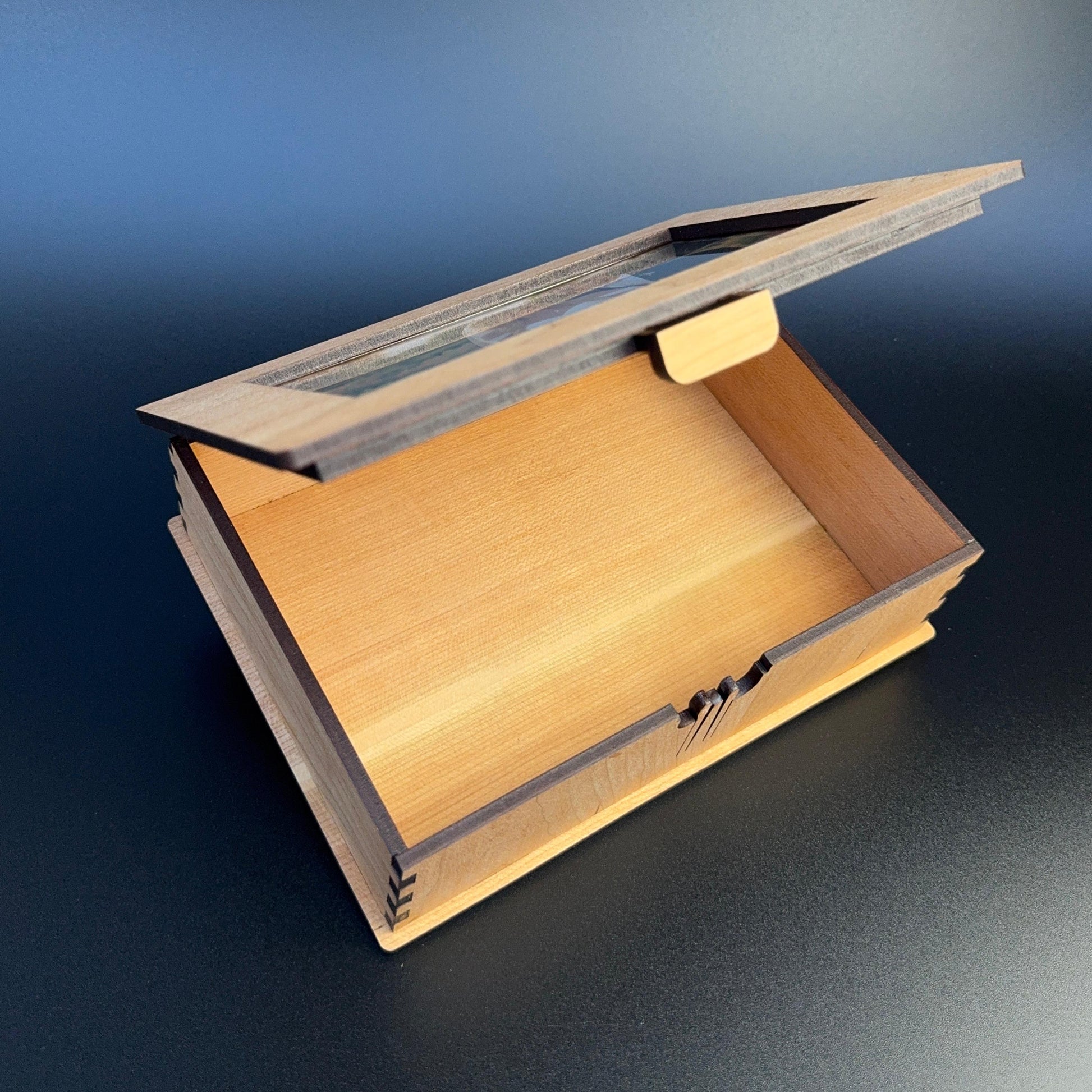 Wooden box with a hinged lid on a gradient blue and gray background