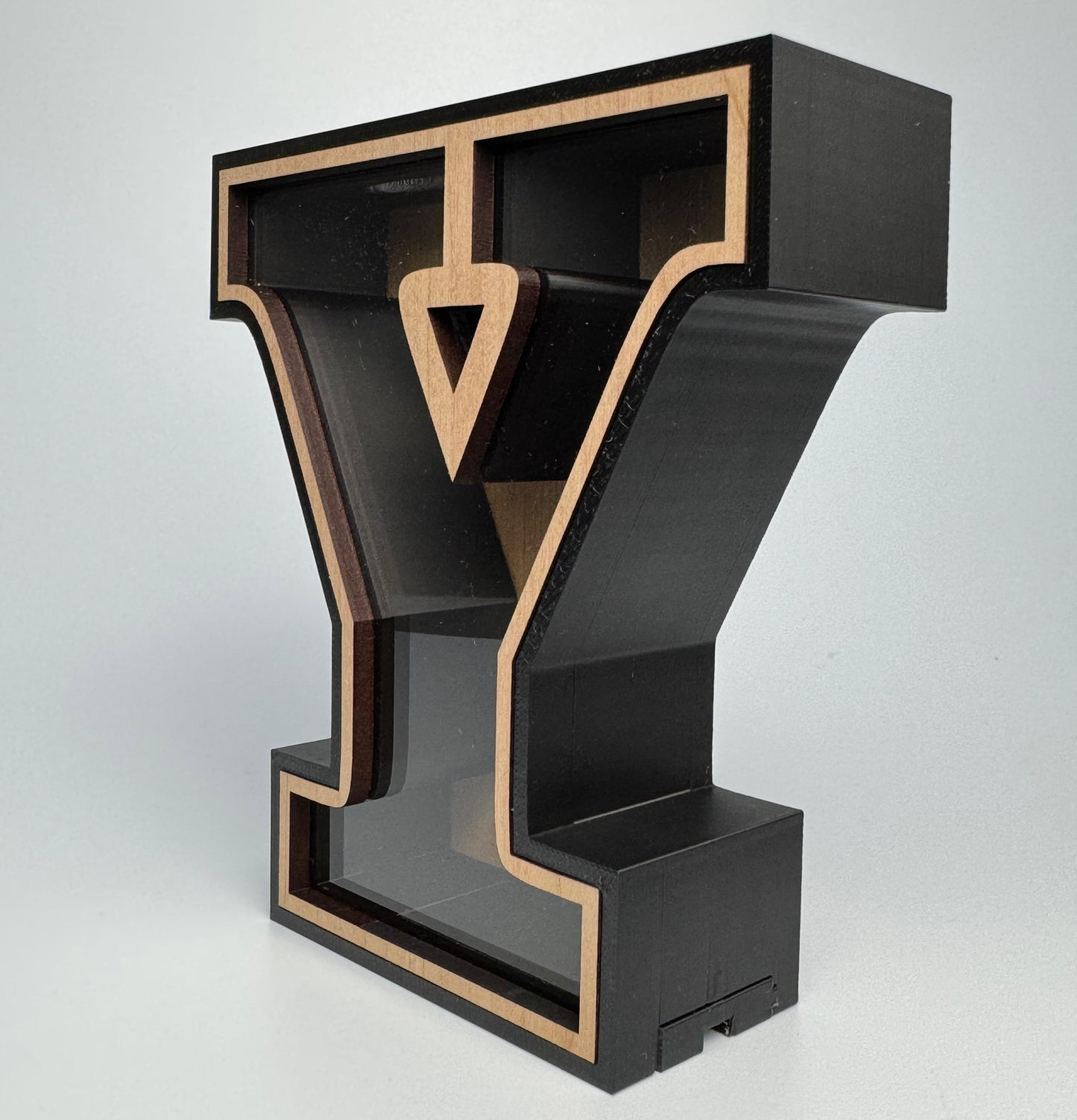 Black and gold letter 'Y' sculpture on a white background
