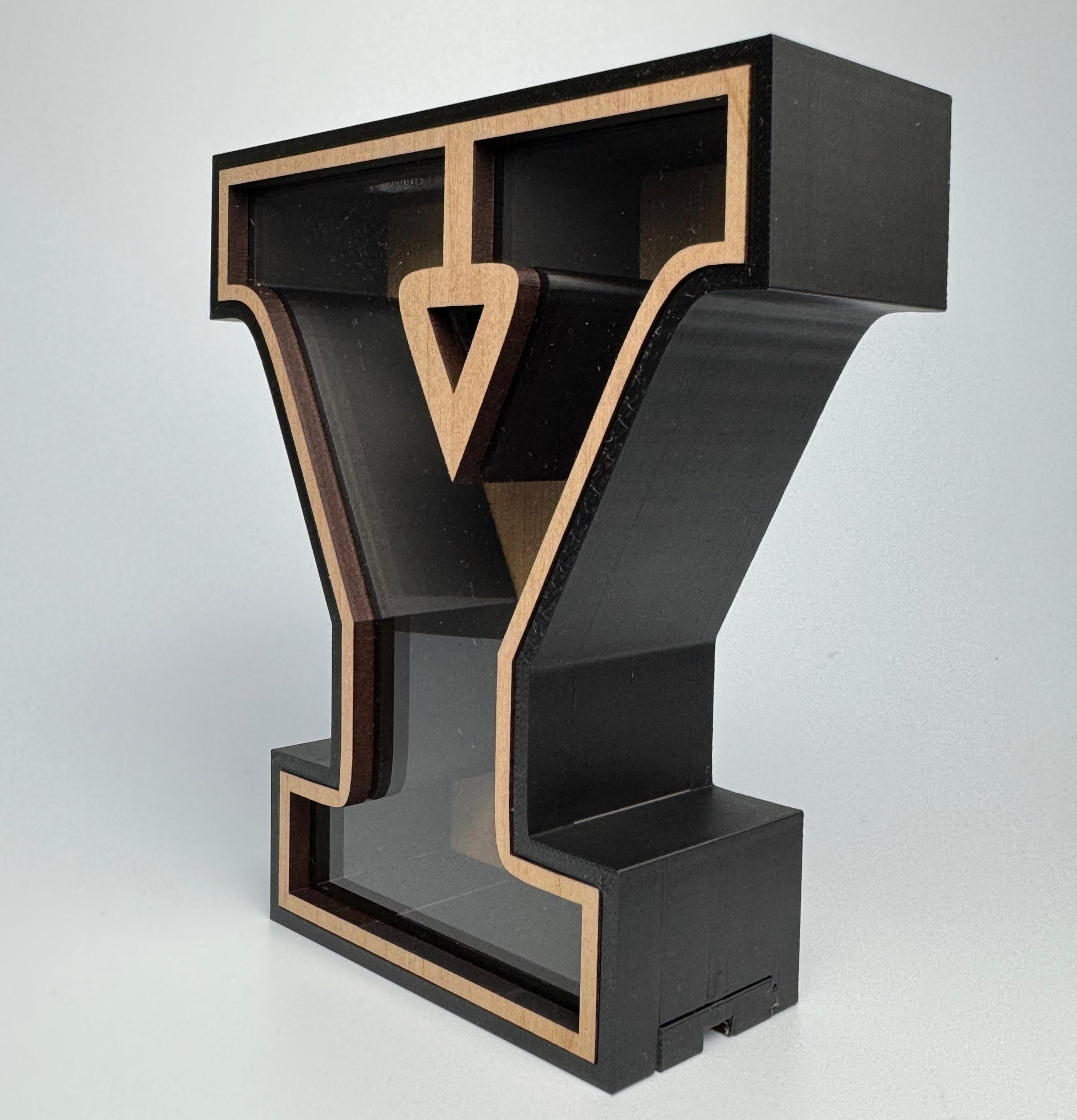 Black and gold letter 'Y' sculpture on a white background