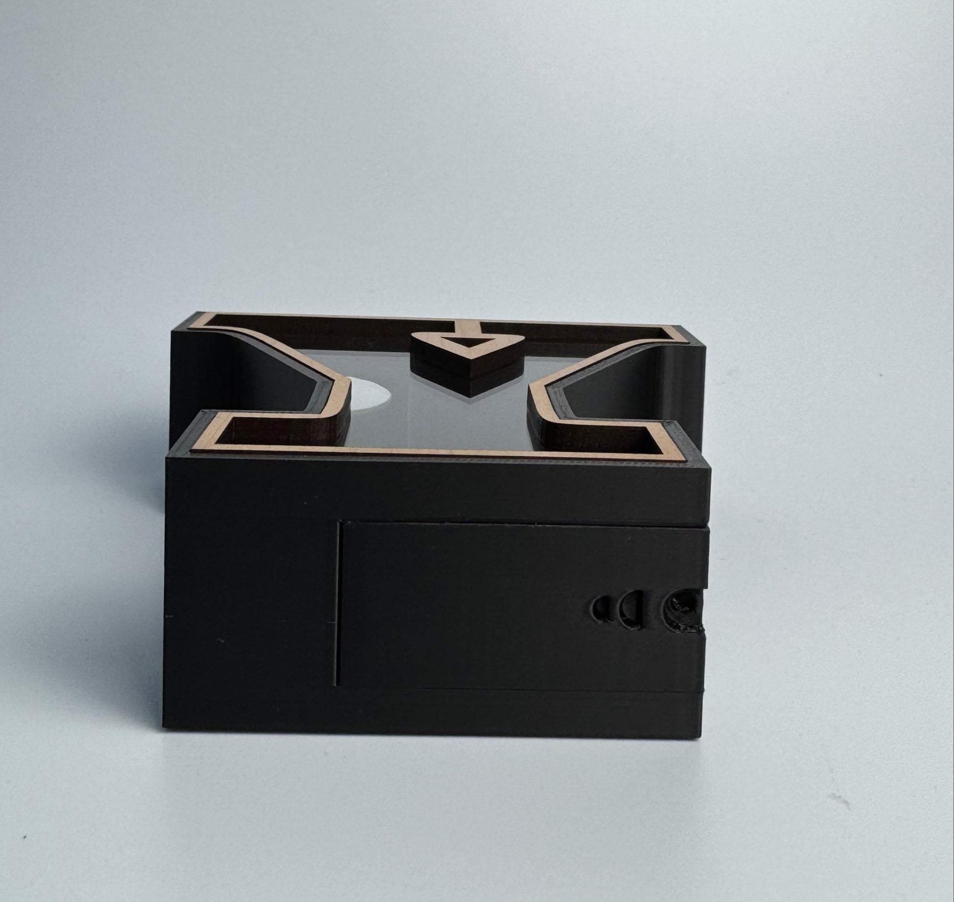 Black rectangular box with geometric design on a light gray background