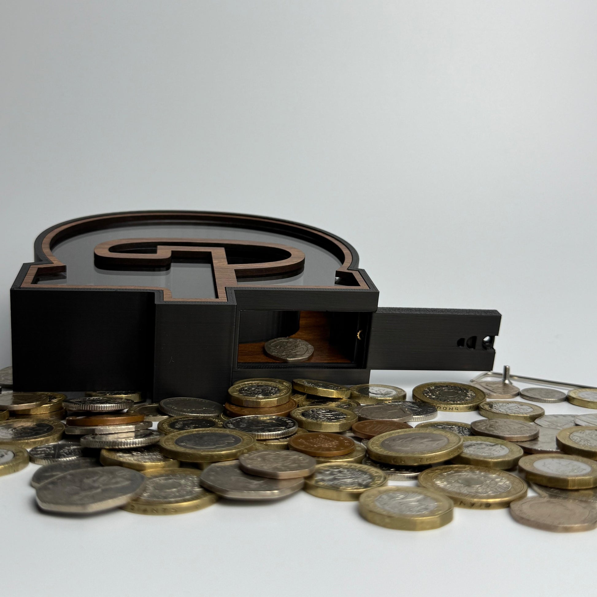 Black money box with coins on a white background