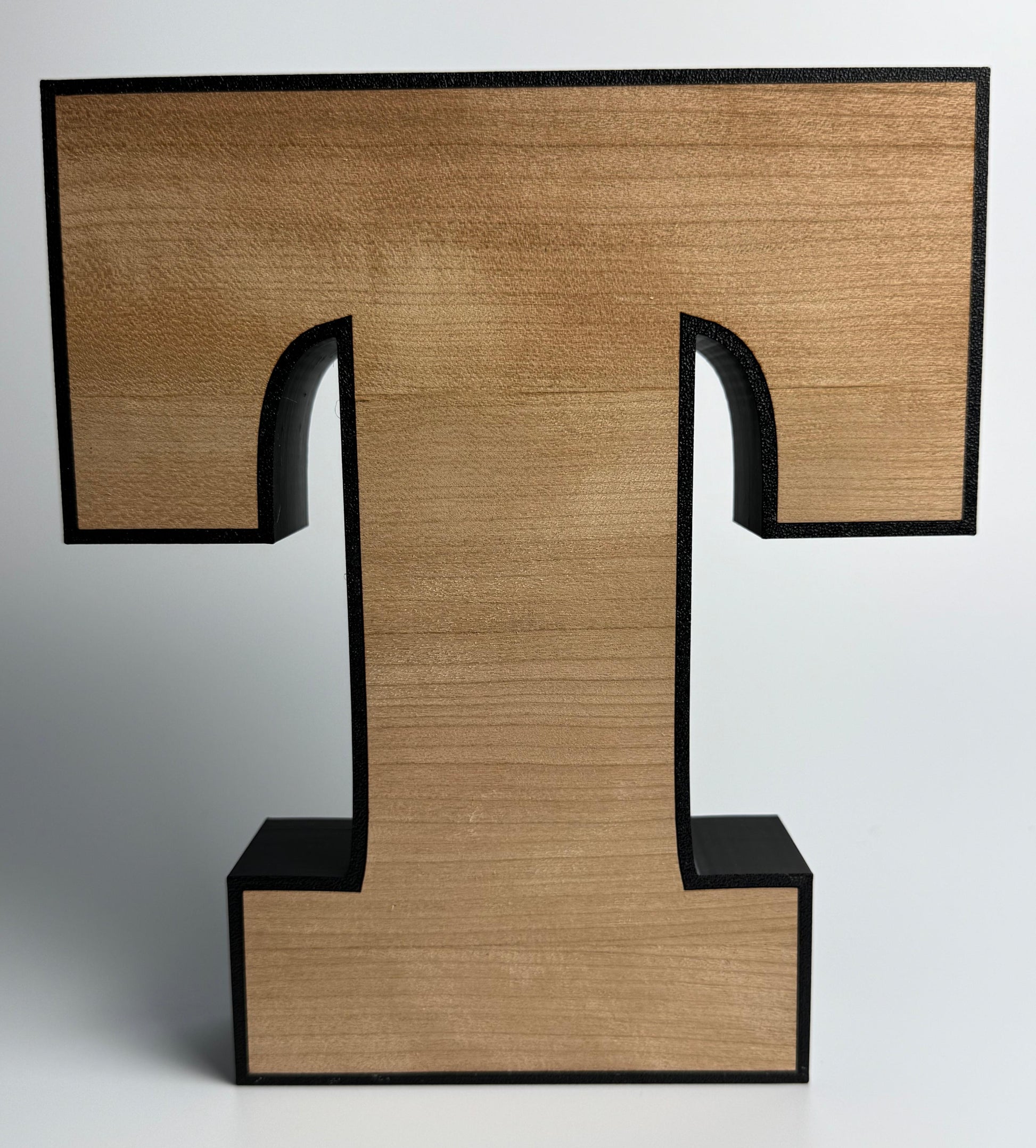 Wooden letter 'T' with a black frame on a white background